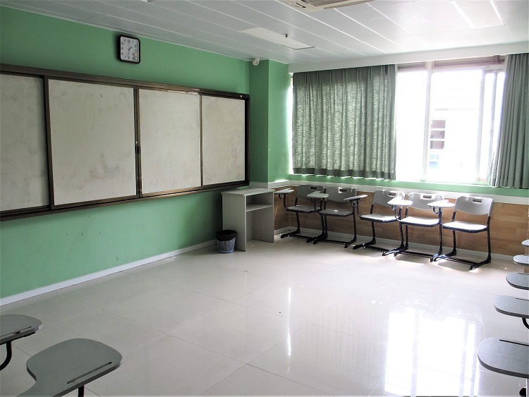 A more modern classroom layout in China with digital board and sliding whiteboard.