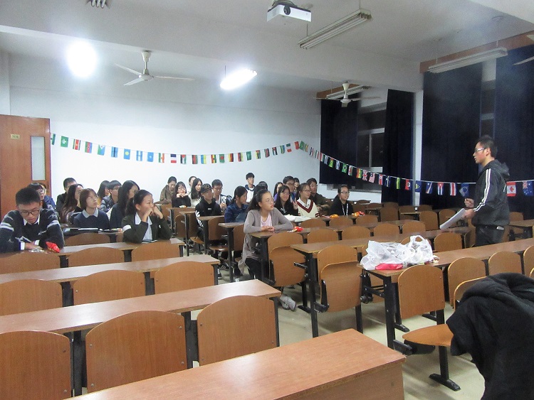 Chinese university students sitting at wooden desks in a classroom.