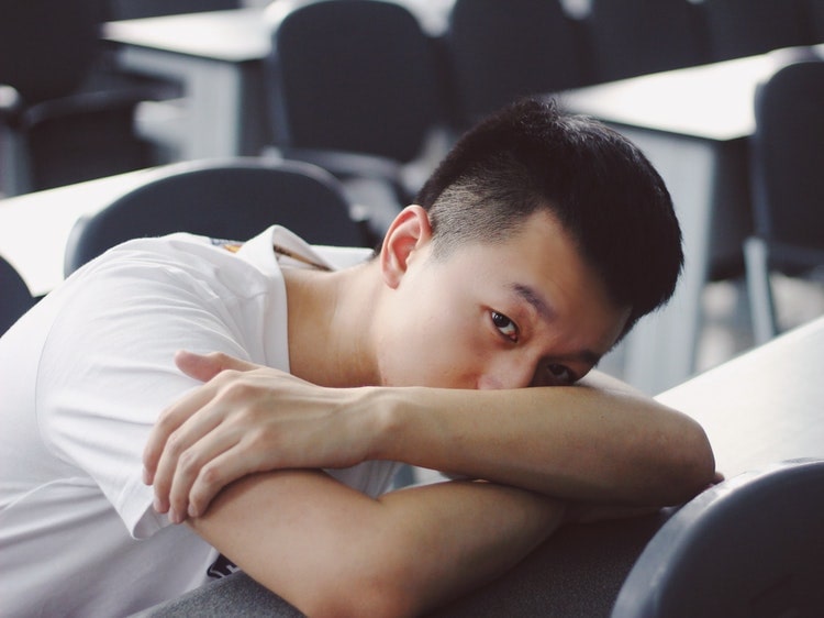 Bored Chinese student laying on desk